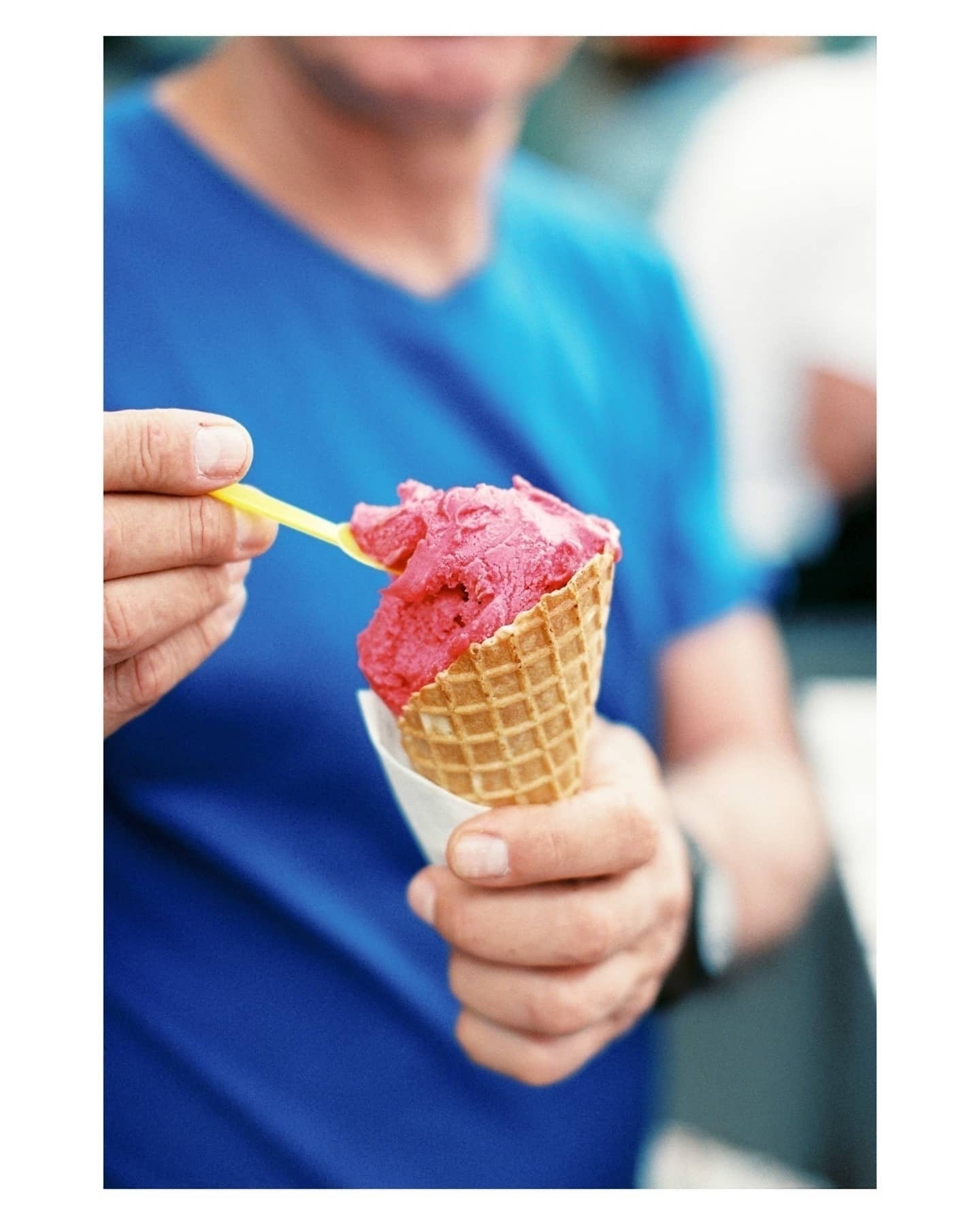 Dad in a blue shirt eating bright pink ice cream